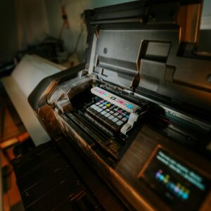 Close-up view of an inkjet printer with exposed cartridges in a workspace setting.