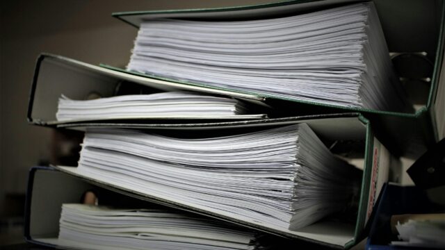 Close-up of stacked binders filled with documents for office or educational use.