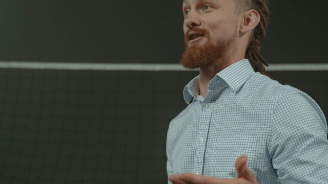 Business coach actively explaining concepts with a tablet in a professional setting.