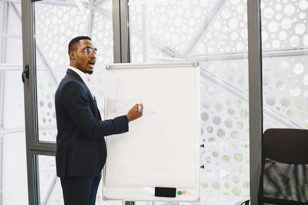 Businessman presenting on a flip chart in a contemporary office setting.