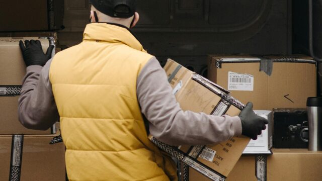 Deliveryman organizing packages into a van for distribution.