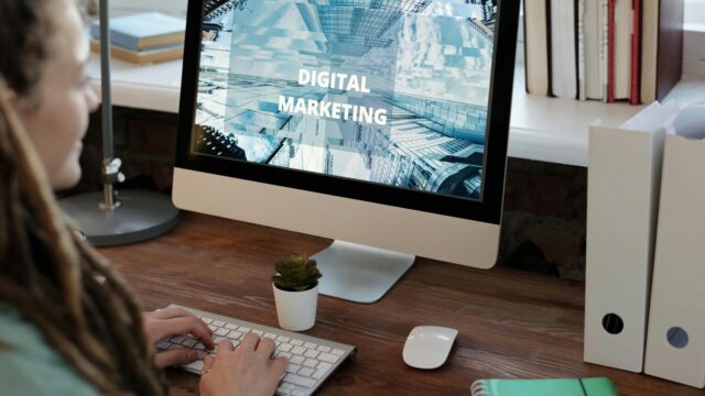Close-up of a woman working on a digital marketing project in a home office setting.