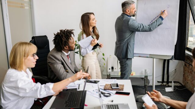 Business professionals brainstorming and collaborating during a team meeting in a modern conference room.