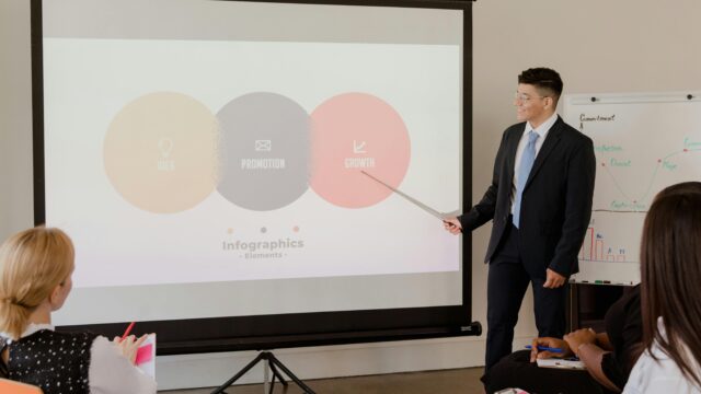 A professional presenting growth strategy with infographics during a business meeting.